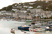 Moored boats in harbour of Mousehole fishing village Cornwall UK