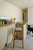 Bar stool at worktop with breadbin and herbs in St Ives kitchen Cornwall UK