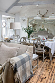 Checked blanket on sofa with dining table and chairs in Marazion beach house Cornwall UK