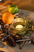 Pinecones fruit and lit candles on table in St Erth cottage Cornwall UK