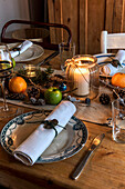 Kerzen und Obst mit alten Tellern und Servietten auf dem Weihnachtstisch in St Erth cottage, Cornwall, Vereinigtes Königreich