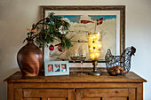Evergreen foliage and nautical picture with egg basket on wooden sideboard Cornish cottage at Christmas St Erth UK