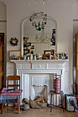 Vintage-Haushaltswaren und -Ornamente mit Spiegel auf weißem Kamin in einem Londoner Haus UK