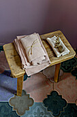Face towels on wooden stool with tiled floor in London bathroom UK