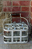 Leere Milchflaschen vor der Tür eines viktorianischen Hauses der Kategorie II in Godalming, Surrey, Großbritannien