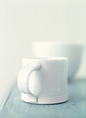 White mug on pale blue wood kitchen table