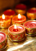 Kleine rote Kerzen mit goldenen Bändern verziert