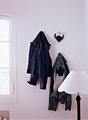 Two denim jackets hanging on the wall