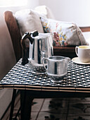 Cast aluminum Picquotware coffee pot and milk jug on woven black and white plastic table