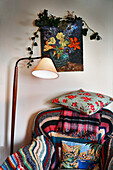 Floral cushion on armchair with crochet blanket and trailing ivy in Shropshire cottage England UK