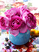 Bright pink flowers in blue vase with dice