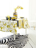 Spring flowers on table with daffodil cloth and zebra print rug