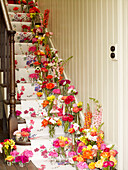 Vases of flowers on staircase with floral wallpaper