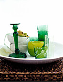 Green glassware and bowls on wicker tray