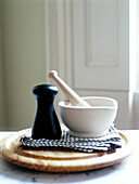 Mortar and pestle and pepperpot on chopping board
