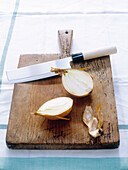 In Scheiben geschnittene Zwiebel mit Küchenmesser auf Schneidebrett