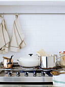 Assorted pans on gas hob with dishcloths