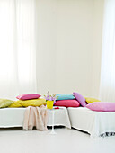 Assorted cushions on white daybeds