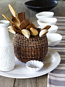 Basket of wooden spoons with white ceramic homeware