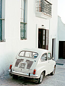White vintage car parked outside Spanish townhouse