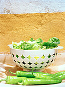 Colander of lettuce with fresh green chili peppers Spain