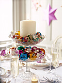 Candle and baubles glass centrepiece with champagne in flutes