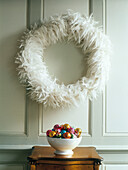 Feather wreath with bowl of baubles on side table