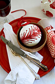 Red and white bauble with knife and fork on tray