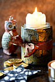 Lit candle tied with gold paper and ribbon