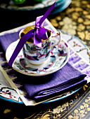 China cup n saucer filled with chocolate coins and tied with ribbon