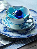 Blue bauble in vintage cup with saucer