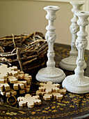Upcycled candlesticks with wooden tree decorations and birds nest on antique tabletop