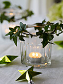 Lit tealight in jar with ivy and stars
