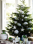Gifts under Christmas tree with white hearts and flowers