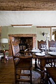 Antique, carved wooden dining chair at table in timber framed cottage, Grafty Green, Kent, England, UK