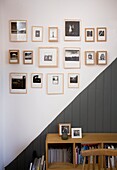 Gerahmte Schwarz-Weiß-Fotografien über grauer Vertäfelung und Anrichte in einem Strandhaus in St Leonards, East Sussex, England, UK