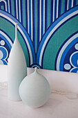 Weiße Vasen und blauer und grüner Retro-Druck in einem Einfamilienhaus in Manchester, England, UK