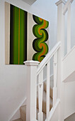 Grünes Retro-Kunstwerk im weißen Treppenhaus eines Einfamilienhauses in Manchester, England, UK