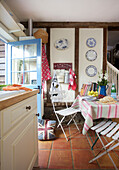 Folding chairs at kitchen table in Egerton cottage, Kent, England, UK