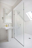 Shower screen with pedestal basin in a wet room of contemporary farmhouse in Nuthurst, West Sussex, England, UK