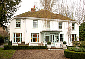 Weiße Außenfassade eines Einfamilienhauses mit Kiesauffahrt in Kent, England, Vereinigtes Königreich