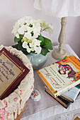 Books and flowers on bedside table in High Halden farmhouse Kent England UK