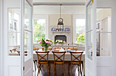 Esstisch und Stühle mit Blick durch Doppeltüren im Haus Kilndown Cranbrook Kent England UK