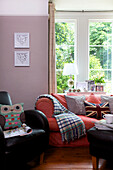 Owl cushion on black leather armchair with sofa at window in Staplehurst living room Kent England UK
