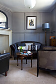 Black leather two-seater sofa and wooden coffee table in Old Town townhouse Portsmouth England UK