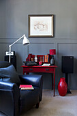 White anglepoise with red lamp and black armchair in living room of Old Town townhouse Portsmouth England UK