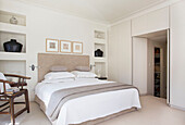 Recessed alcoves with double bed and wooden chair in Wandsworth home London England UK