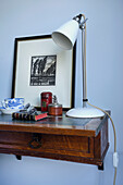 White lamp and book with artwork and reading glasses on bedside table in Emsworth bedroom Hampshire England UK