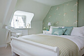 Light green patterned wallpaper and dormer window in Dorset cottage bedroom Corfe Castle England UK