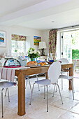 Weiße Stühle am hölzernen Küchentisch in Bishops Sutton home Alresford Hampshire England UK
